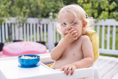 High angle view of cute baby girl sitting on table