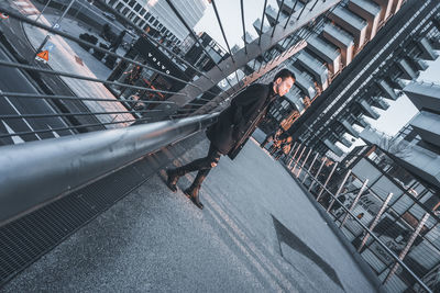 Reflection of man on railing in city