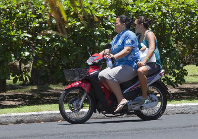 Side view of people riding motorcycle