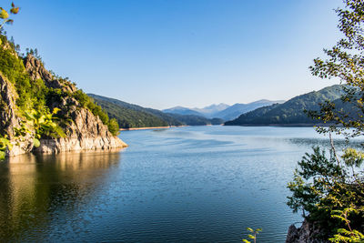 Scenic view of lake against clear blue sky