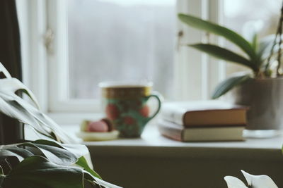 Coffee cup and books on table at home