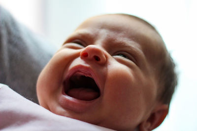 Close-up of cute baby crying at home