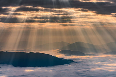 Sunlight streaming through clouds during sunset