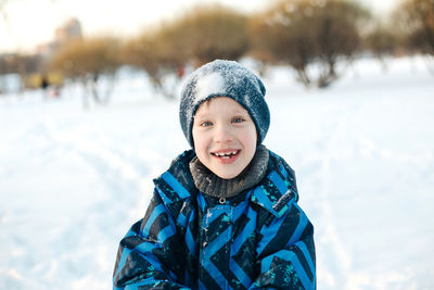Portrait of smiling boy in snow outdoors