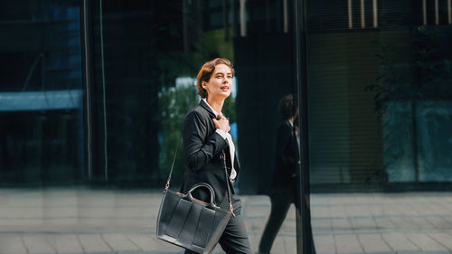 Woman with umbrella walking in city