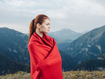 Young woman standing against mountain