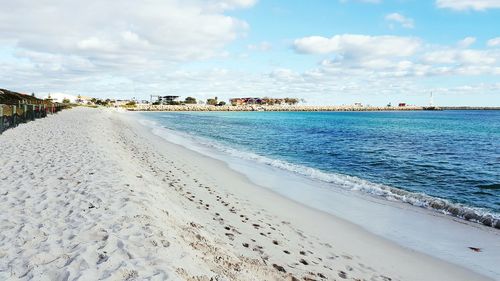 Scenic view of beach against cloudy sky