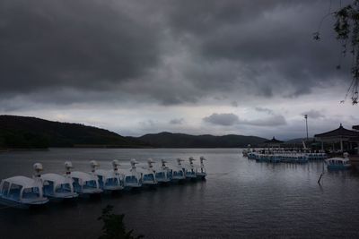 Boats moored in lake against sky