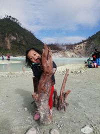 Friends enjoying at beach against sky