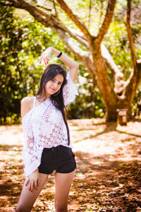 Portrait of smiling young woman in forest