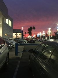 Cars on illuminated city against sky at night