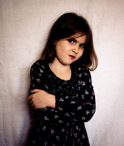 Portrait of young woman against wall