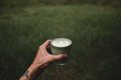 Matcha tea latte on hand backgruond