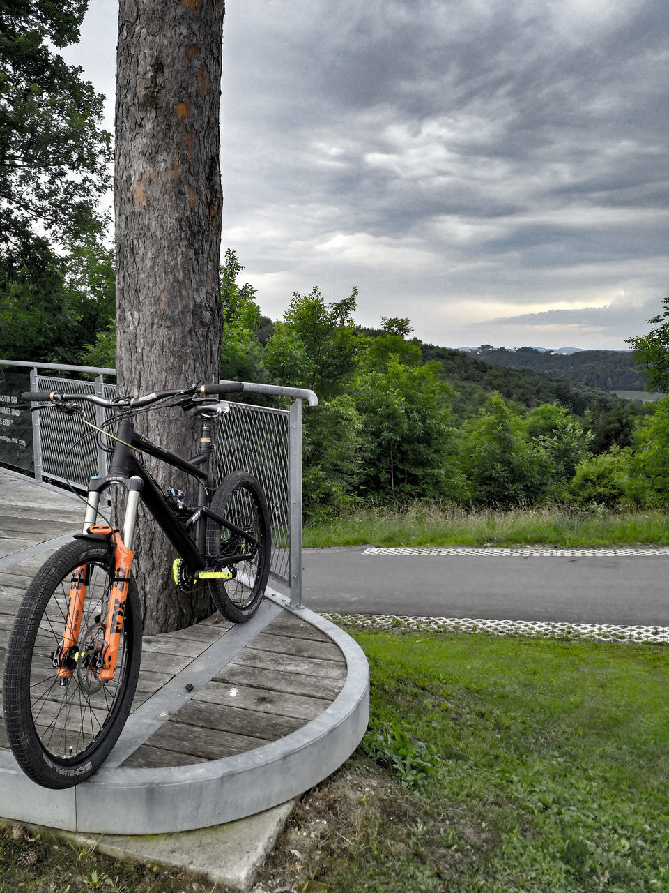 BICYCLE PARKED ON ROAD AGAINST SKY