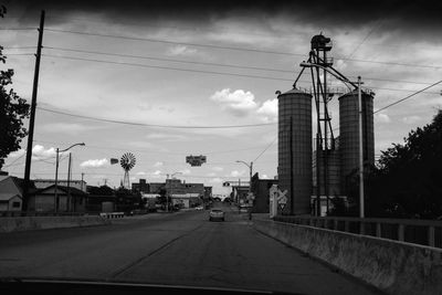 Road amidst buildings in city against sky