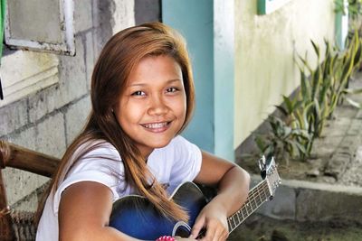 Portrait of smiling girl with guitar