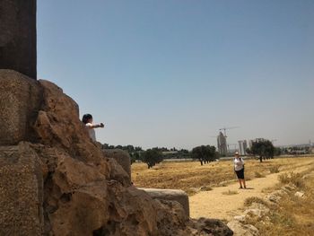 Rear view of man standing against clear sky