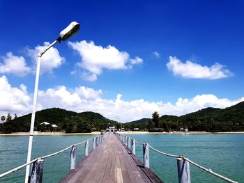 Street amidst sea against sky