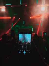 Rear view of people photographing at music concert
