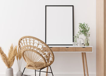 Empty vertical picture frame standing on wooden desk in modern living room. mock up interior 