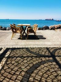 Chairs on beach against clear sky