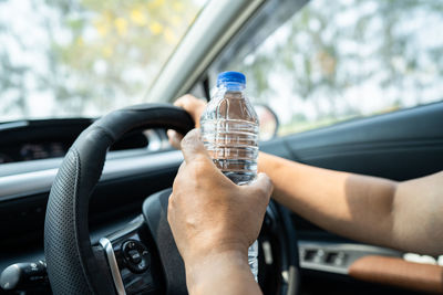 Cropped hand of man driving car