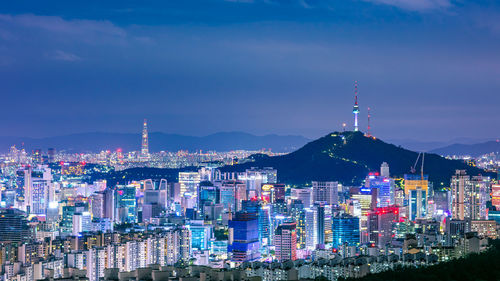 Illuminated cityscape against sky at night