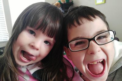 Close-up portrait of happy siblings at home