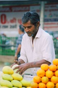 Side view of young woman picking tomatoes