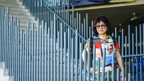 Portrait of pretty lady standing by railing