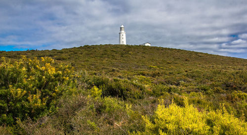 Scenic view of lighthouse by land against sky