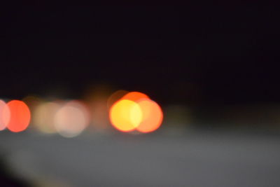 Defocused lights against sky at night