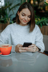 Portrait of young woman using mobile phone