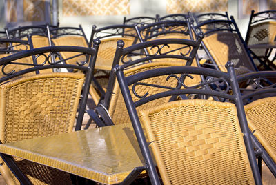 Wicker chairs and tables at sidewalk cafe during sunny day