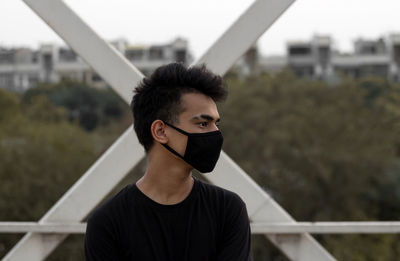 A young male put a mask on to avoid coronavirus infection in a city.