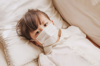 High angle view of baby lying on bed