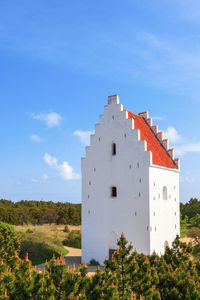 Sand dunes landscape with sand-covered church in skagen, denmark.