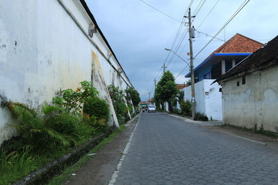 Road amidst buildings against sky