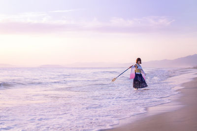 Rear view of man in sea against sky