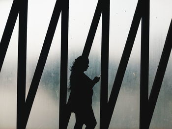 Silhouette woman walking against frosted glass