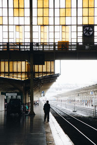 Rear view of silhouette people walking at railroad station