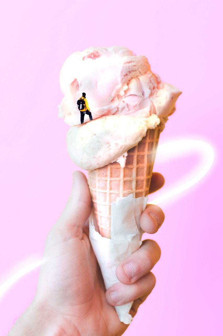 MIDSECTION OF WOMAN HOLDING ICE CREAM CONE