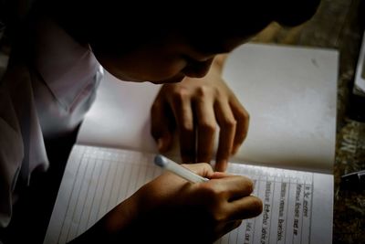 High angle view of man reading book on table