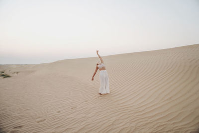 Woman in the desert with arms raised