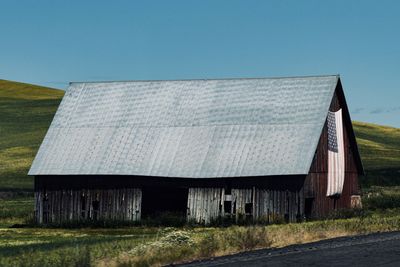 Exterior of house on field against clear sky
