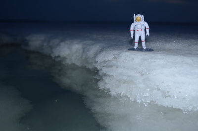 Astronaut figurine on salt at night