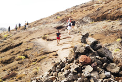 Rear view of people walking on rocks