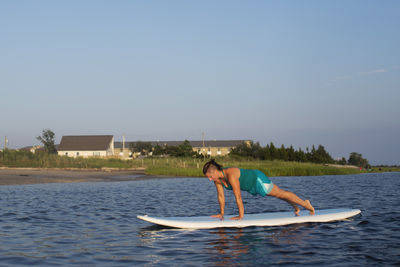 Man surfing in sea against clear sky