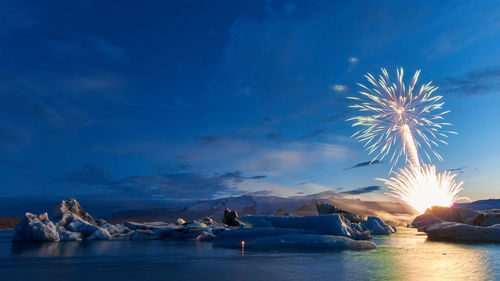 Firework display over sea during winter at dusk