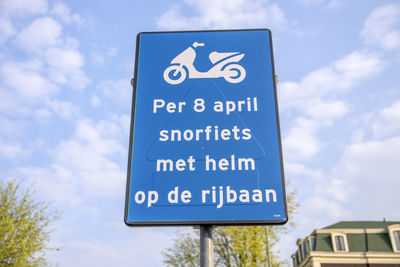 Low angle view of road sign against sky